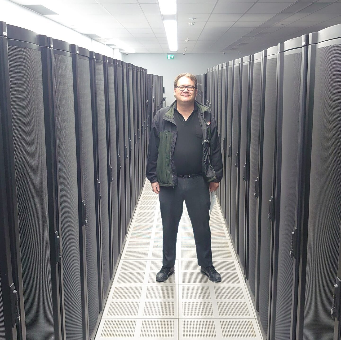Collin Richard, principal of CJR Digital Solutions, standing in a data center server aisle.